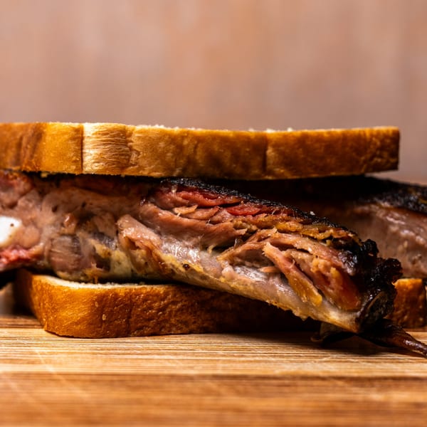 Close-up of a Hot Spot Barbecue rib sandwich with tender meat between two slices of bread.