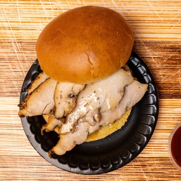 Top-down view of a Hot Spot Barbecue pulled pork sandwich on a black plate.