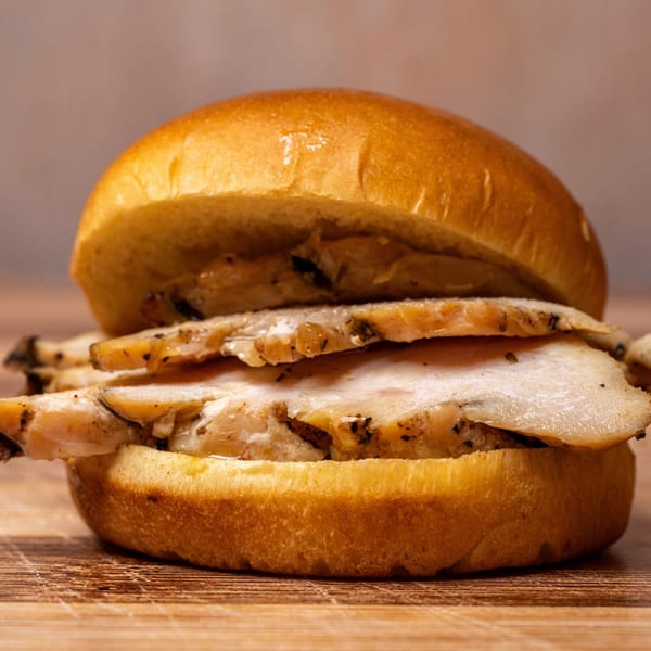 Hot Spot Barbecue's grilled chicken sandwich on a brioche bun, showcasing tender, seasoned chicken slices.
